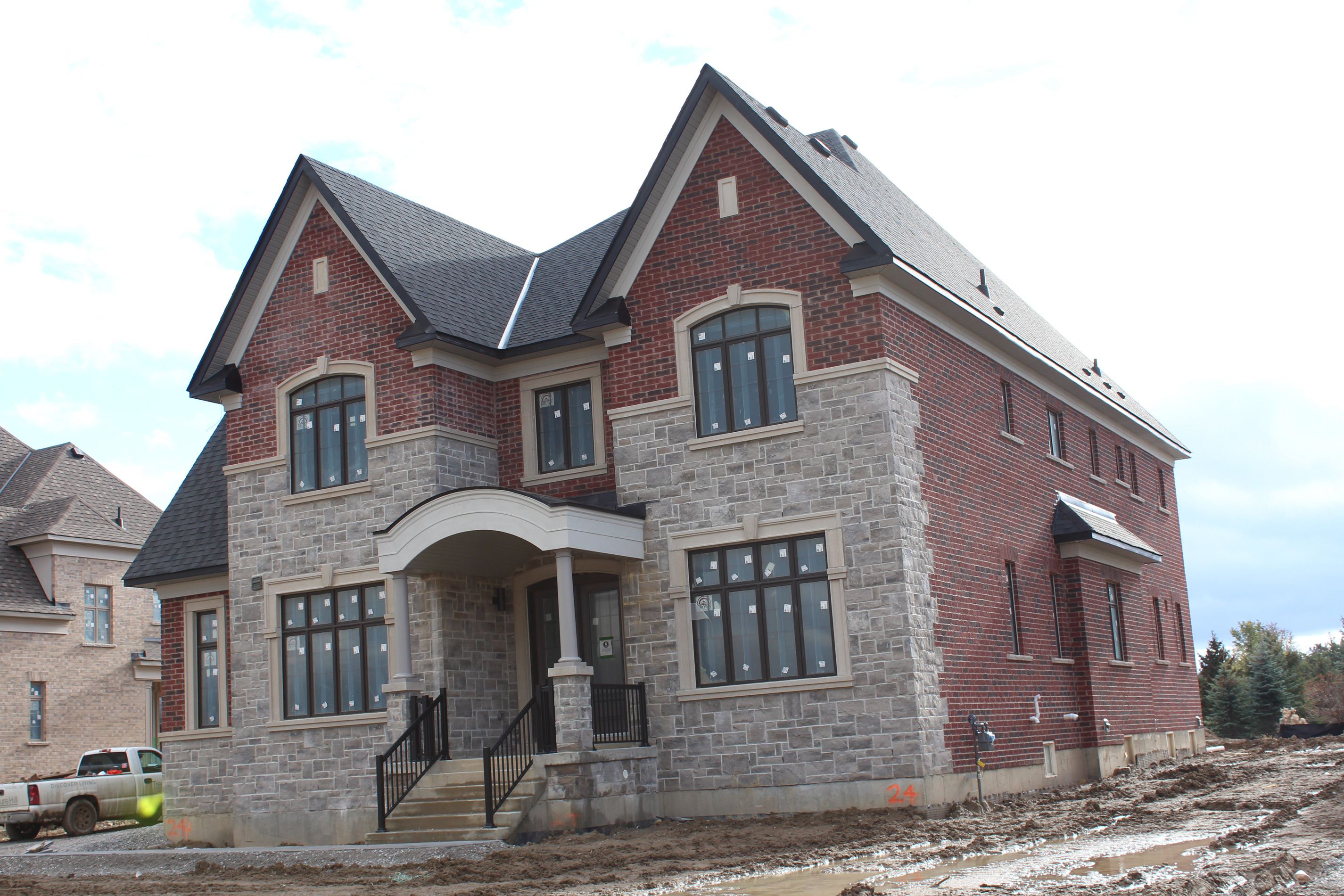 Wide angled shot of residential house. - Brick color is Wellington, Stone color is Chambord Grey with.