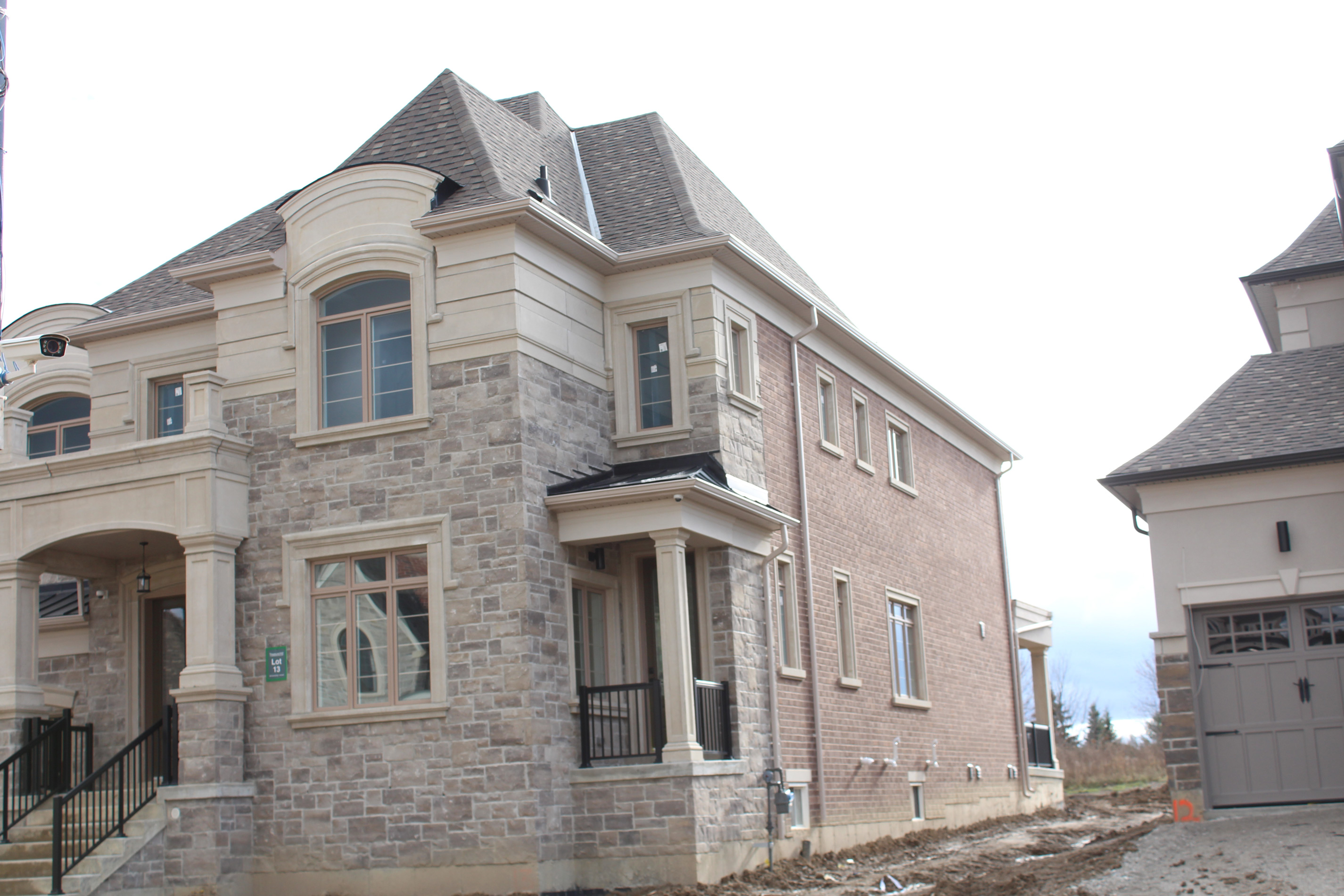 Angled corner shot of residential home. - Brick color is Abion, Stone color is Margaux Beige.